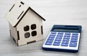 Image représentant une maison et une calculatrice pour inviter les gens à effectuer une simulation pour calculer le coût de leur projet de rénovation énergétique en ligne gratuitement